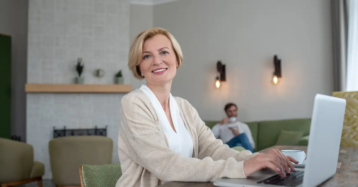 Właścicielka pensjonatu sprawdza rezerwacje w systemie na laptopie